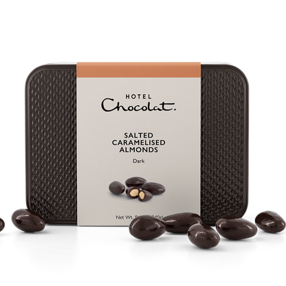 Dark Chocolate Covered Salted Carmelised Almonds piled in front of tin. 